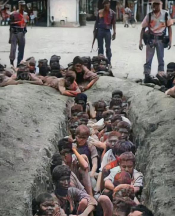 1965年，这是一张印尼军警屠杀“华人”的现场照片，近百名华人被迫聚集在一处土坑