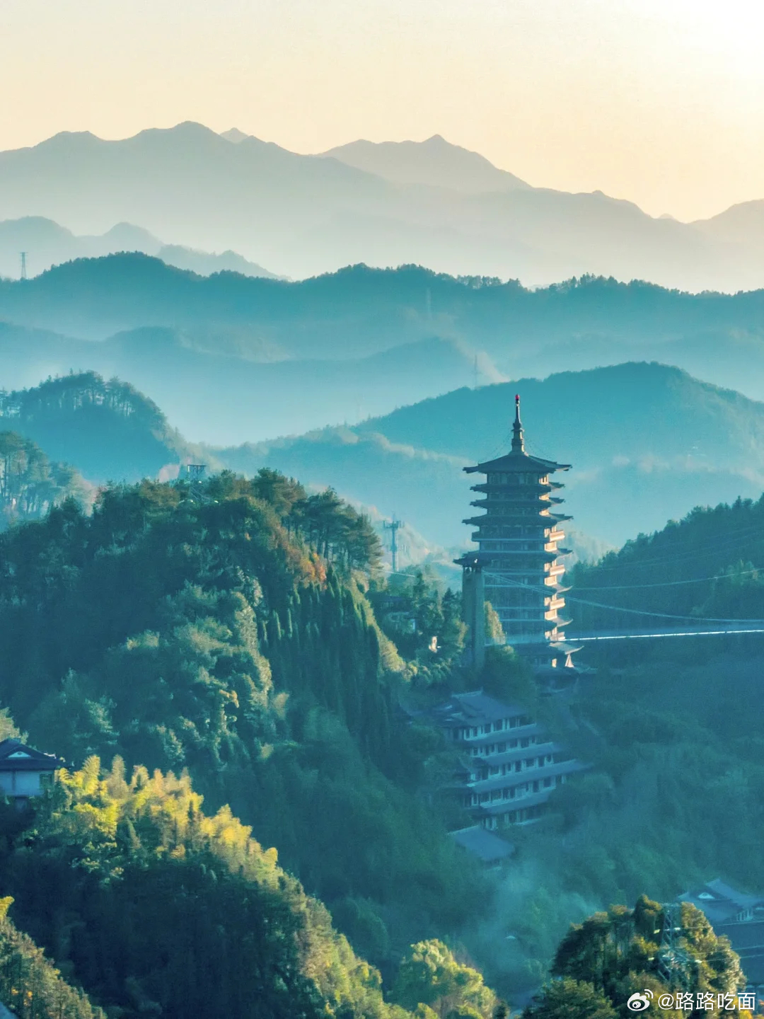 远山连绵，高塔立于青山之上，云雾漫过群峰，满目皆是山水诗意。 