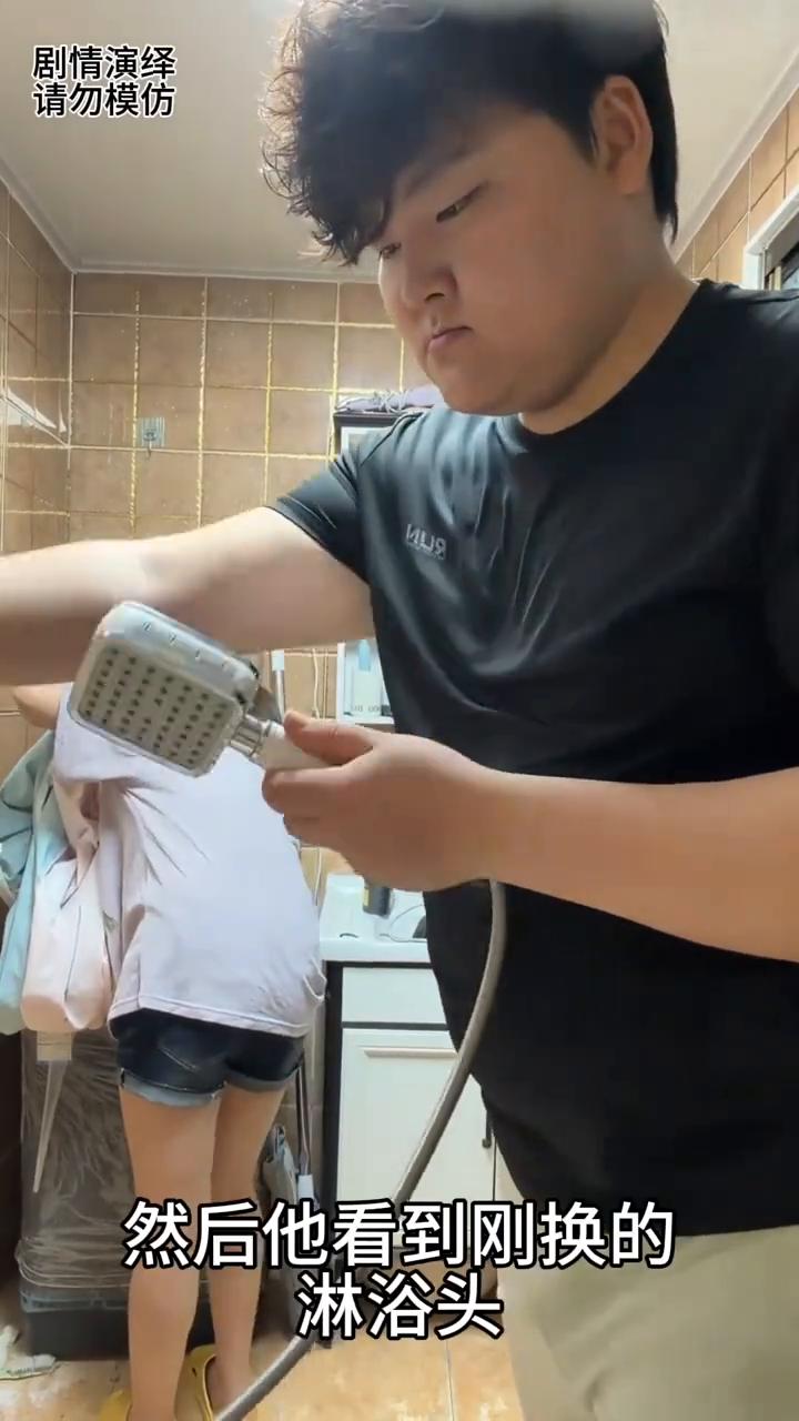 男子拿着刚换的淋浴头看看怎么样，谁知呲了一脸，让他很无奈。
男子来到洗澡间，然后