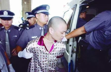 2002年，一个名叫廖坤的罪犯被验明正身，即将被押解赴刑场接受处决，照片中的他穿