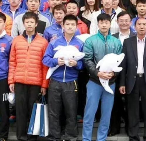 这张合照，我居然只认出了抱着鲨鱼玩偶的马龙与樊振东，那位拎着手提袋、穿着橙色羽绒