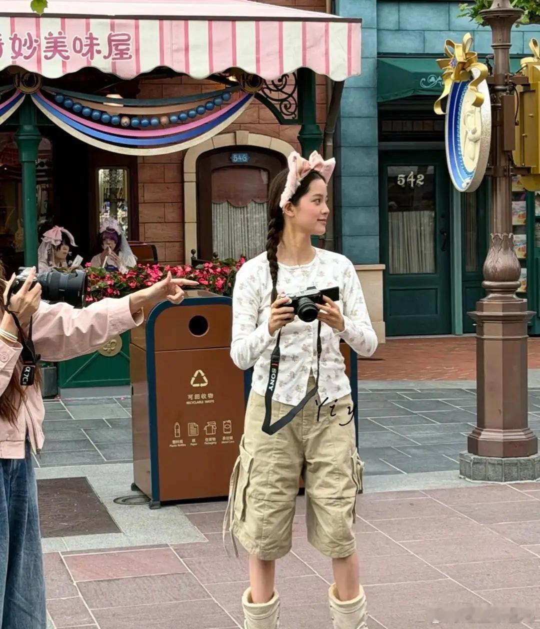 欧阳娜娜现身上海迪士尼乐园游玩被偶遇，她的打扮时尚有型，扎着双麻花辫，头戴粉色蝴
