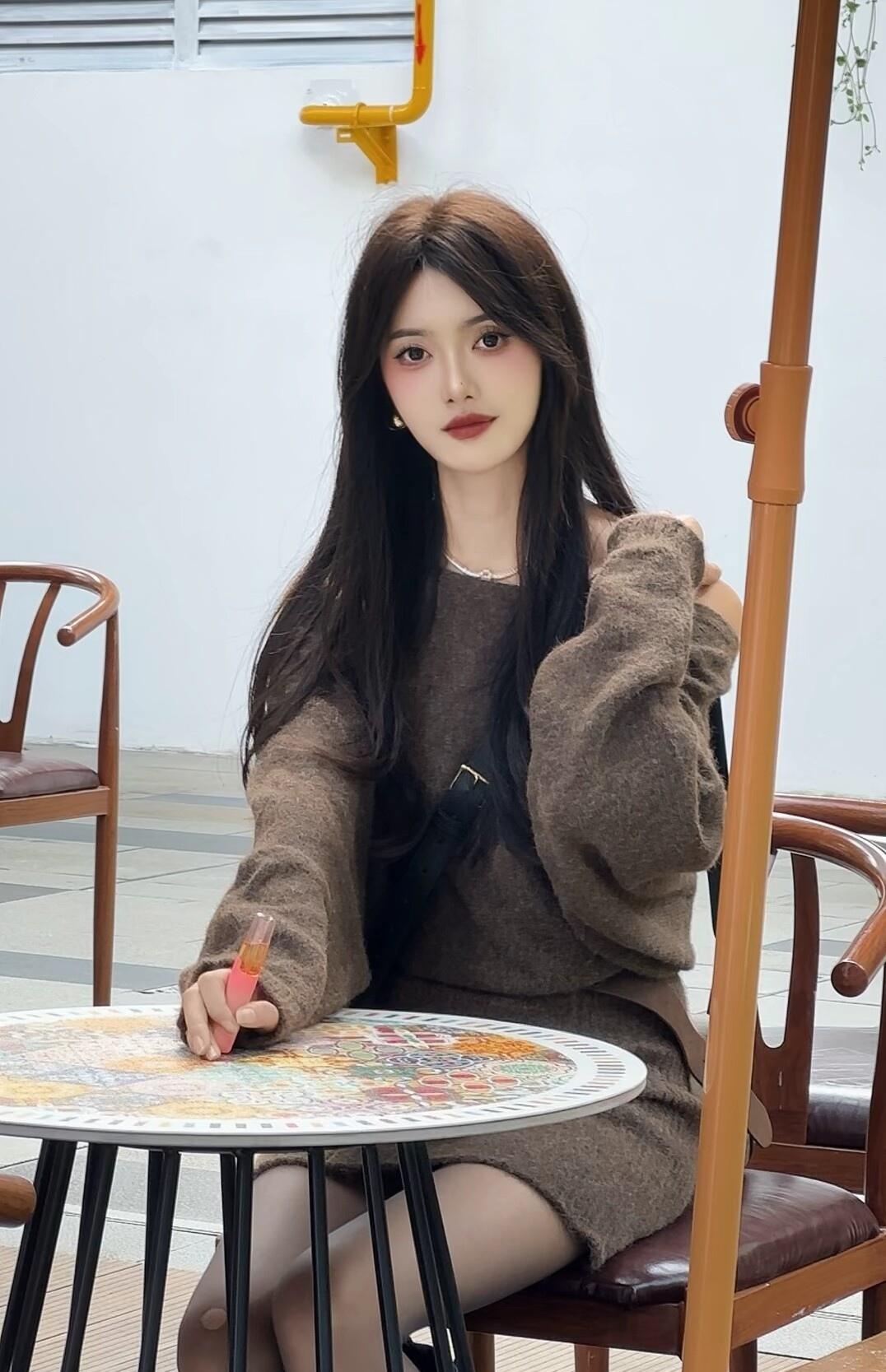 手里的画笔悬在彩色的桌布上，笔尖还沾着一点未干透的暖橘色。
 
棕色毛衣的绒线裹