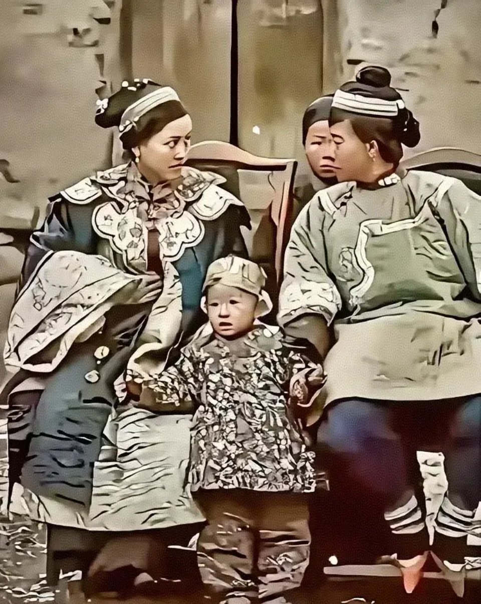 这是清朝的一大户人家，正妻和小妾前面分别坐着，前面依偎着一个3，4岁左右的小孩，