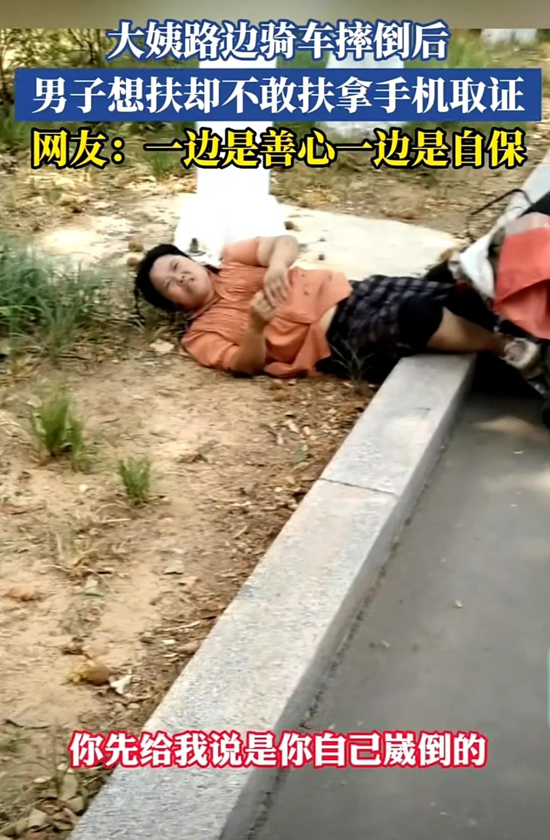 山东，一大姨路边骑车摔倒后，男子想扶却不敢扶，先拿手机取证，网友：一边是善心一边