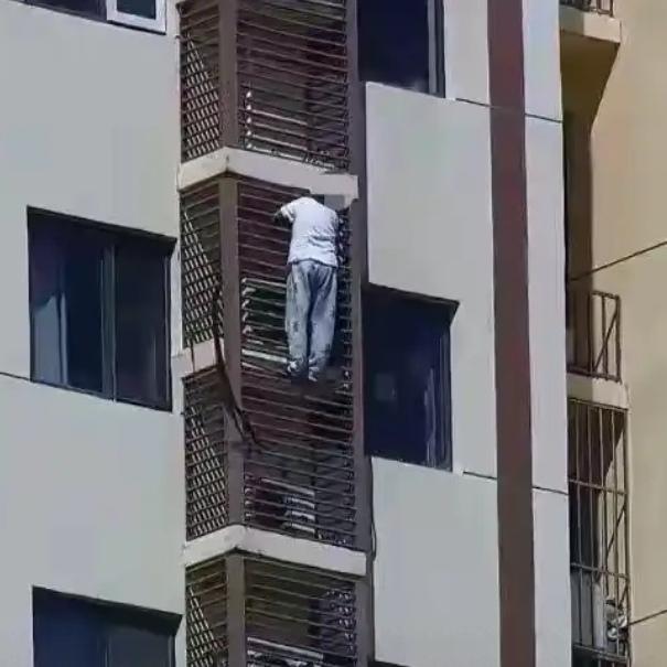 26层高空，一头白发的老人竟然死死扒在空调外机护栏上，命悬一线！这不是电影特效，
