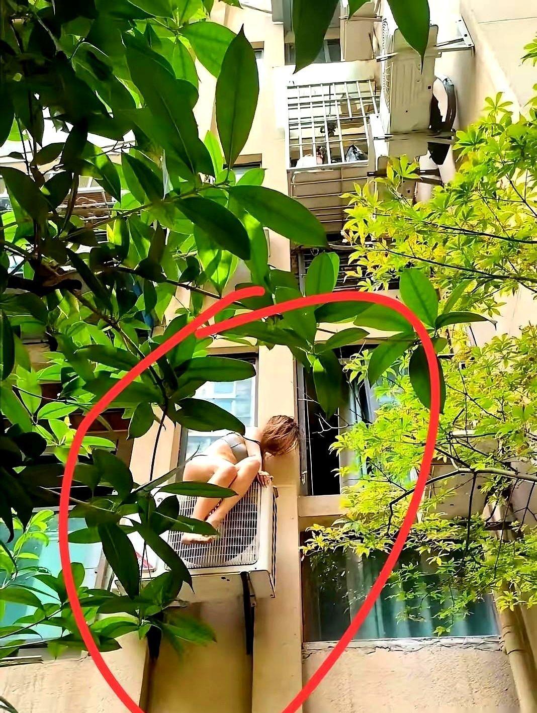 她站在21楼的空调外机上，不是拍视频，是撑不住了。
没人真以为她在耍酷。
只是大