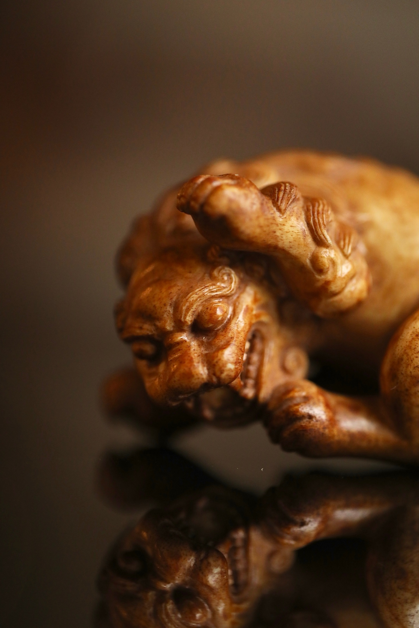 鹿角 | 瑞兽把件器体以圆雕技法，塑一回首卧兽。瑞兽眉目清秀，卷眉含笑，口微张露