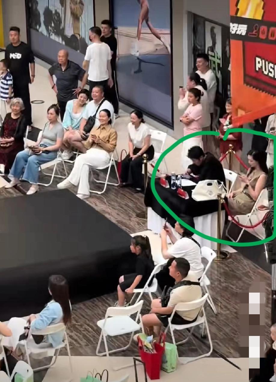 一商场内正在举行“少儿模特大赛”，“模特”们在台上卖力的表演，可台下这一男一女两