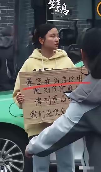 四川成都，华西医院门口有一个女孩子胸前举着一块牌子，写着提供免费住宿吃饭，很多人