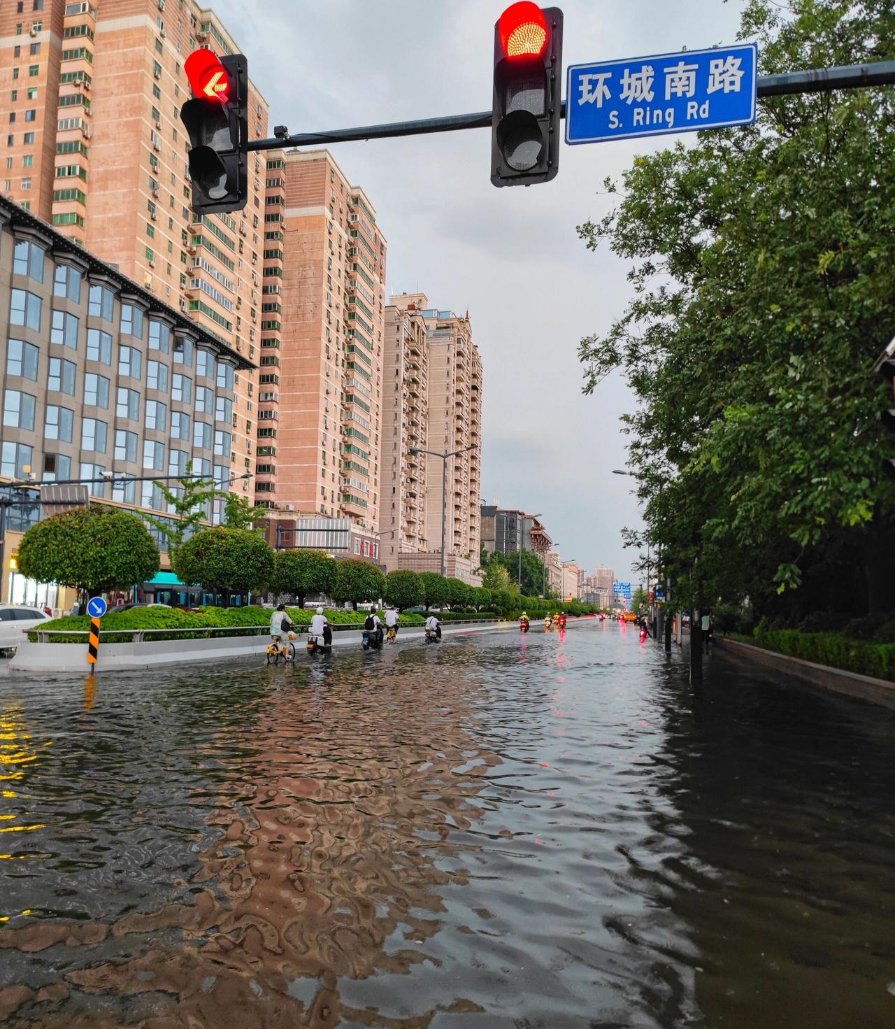 西安狂风暴雨后朱雀大街和环城南路都积水严重，行人淌水行走，道路严重拥堵