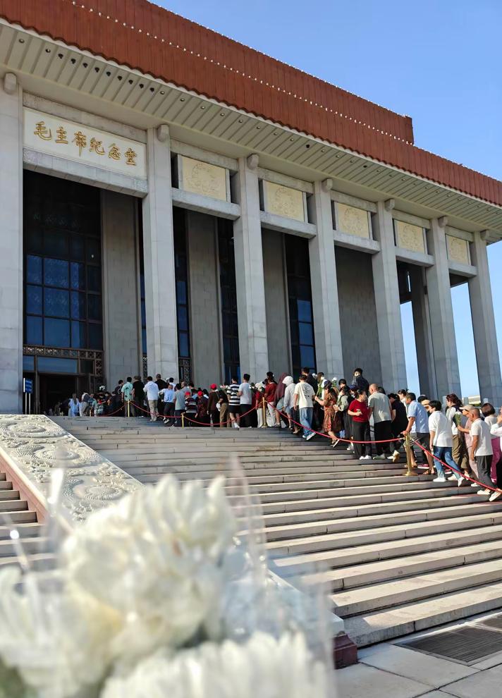 今天毛主席纪念堂门口  
人山人海  
来瞻仰伟人遗容的人很多
大家都手拿白色菊