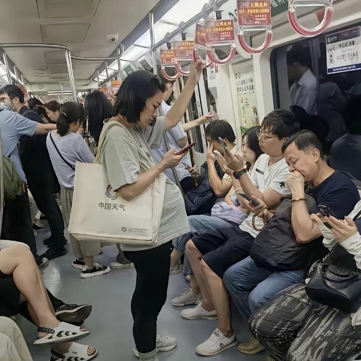 地铁上，一位挺着大肚子的孕妇站在车厢中间，肚子沉甸甸的，全程死死抓着扶手，车子一