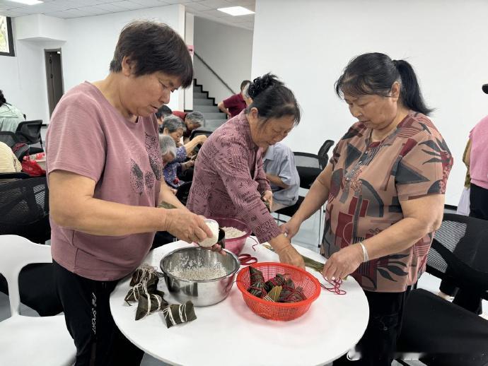 粽香飘满台州邻里围坐包出幸福味街坊邻里围坐一起协作包粽子，满城粽香四溢，一枚枚粽
