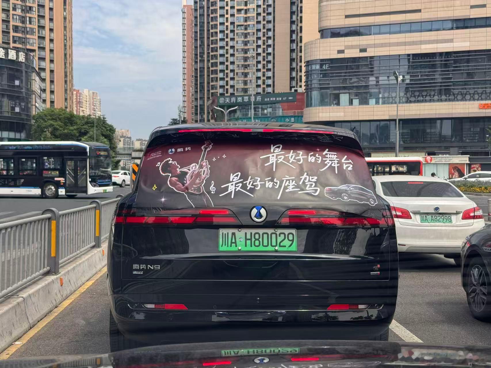 黄昏时分车队驶过滨江路，落日余晖落在车身上，应援贴纸在光影下格外有氛围感，随手出