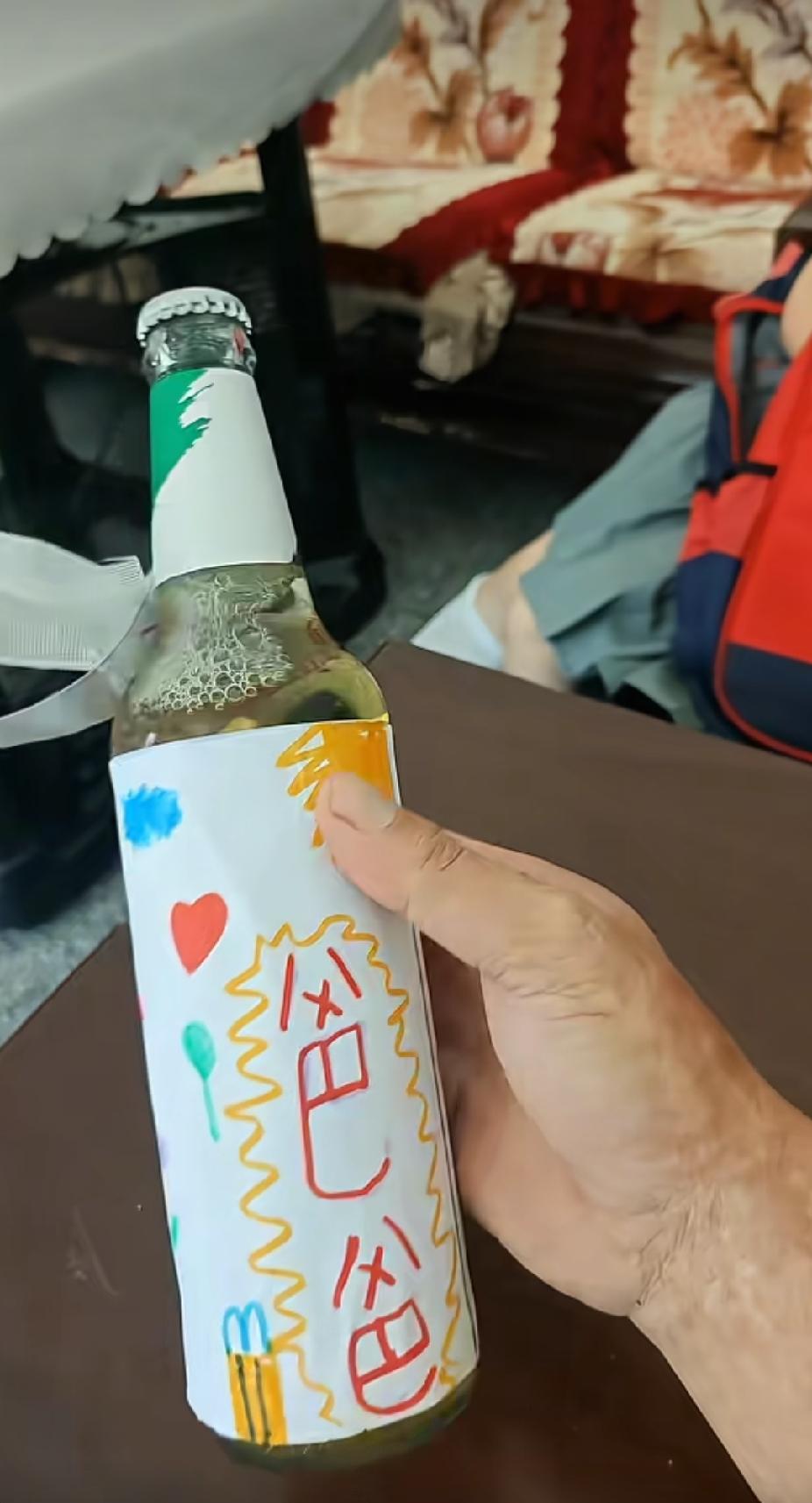 女儿放学回家，从书包里掏出一个瓶子递给爸爸，爸爸看见瓶子上的包装纸，瞬间就感动了