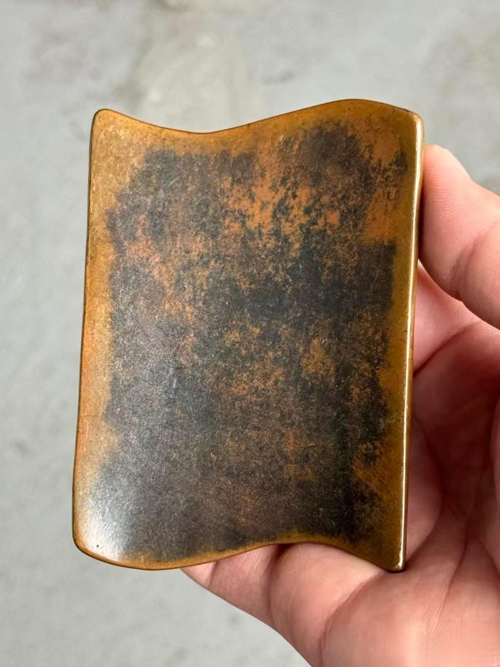 公公床底下翻出来的，我以为是铁的，用磁铁吸了下没吸住。巴掌大，铜色发黑，瓦形的，