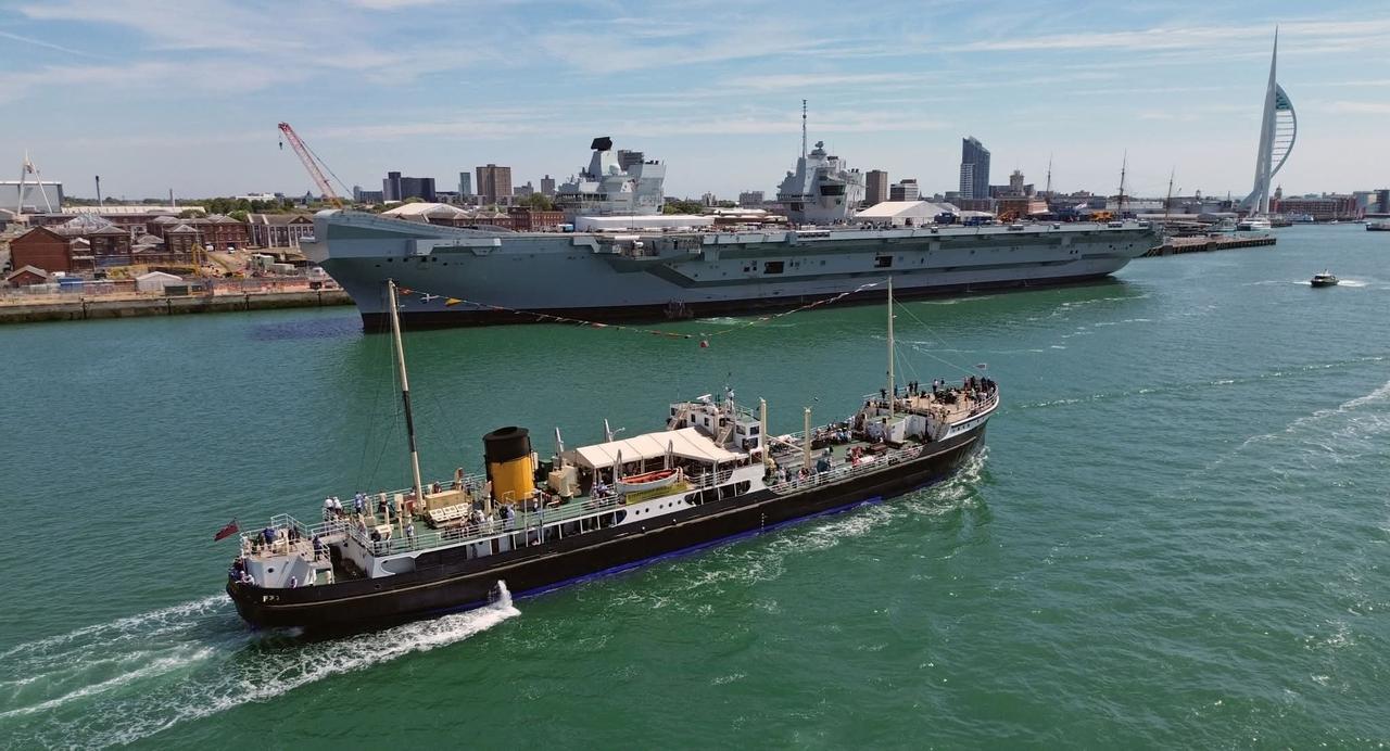 蒸汽船“希尔德霍尔”号（SS Shieldhall）驶过朴茨茅斯港停泊的航空母舰