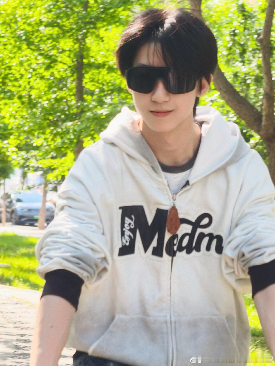 杨博文踏进春天的新绿里杨博文白色毛毛怪 在春天的新绿里骑行的杨博文，卫衣墨镜牛仔