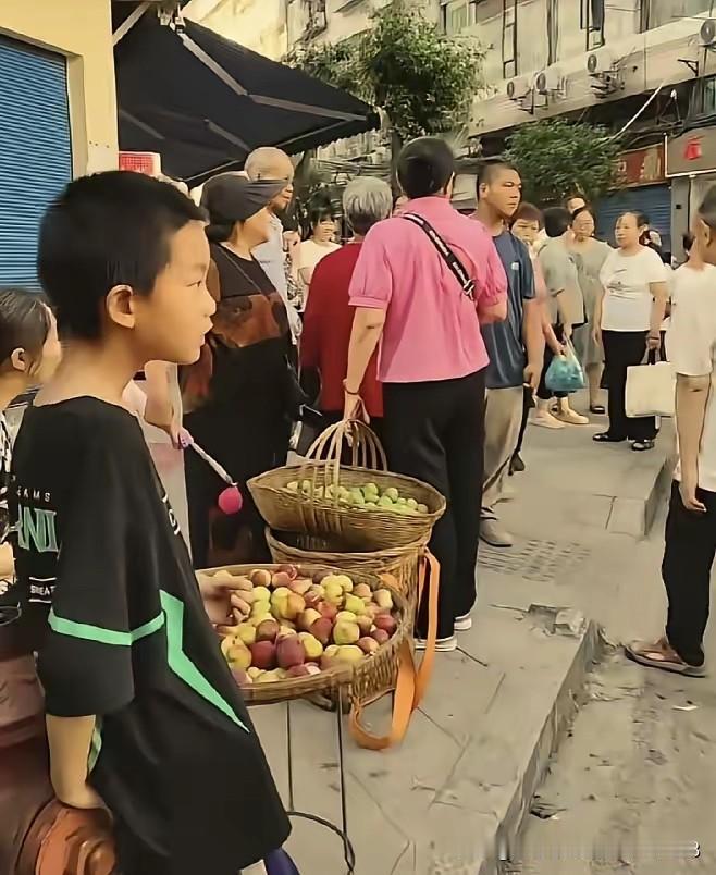 近日，四川达州市。一名 10 多岁的男孩在街上摆摊卖自家产出的李子。辛辛苦苦卖了