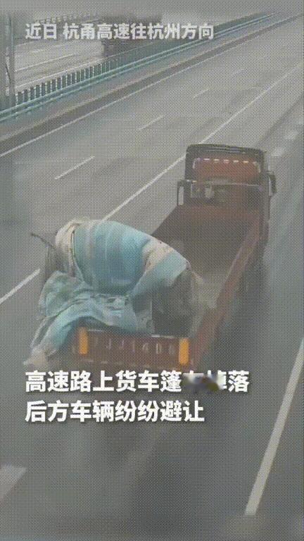 火到人民日报了！天色渐黑，杭甬高速往杭州方向，一大货车货斗的篷布突然被风兜掉到了