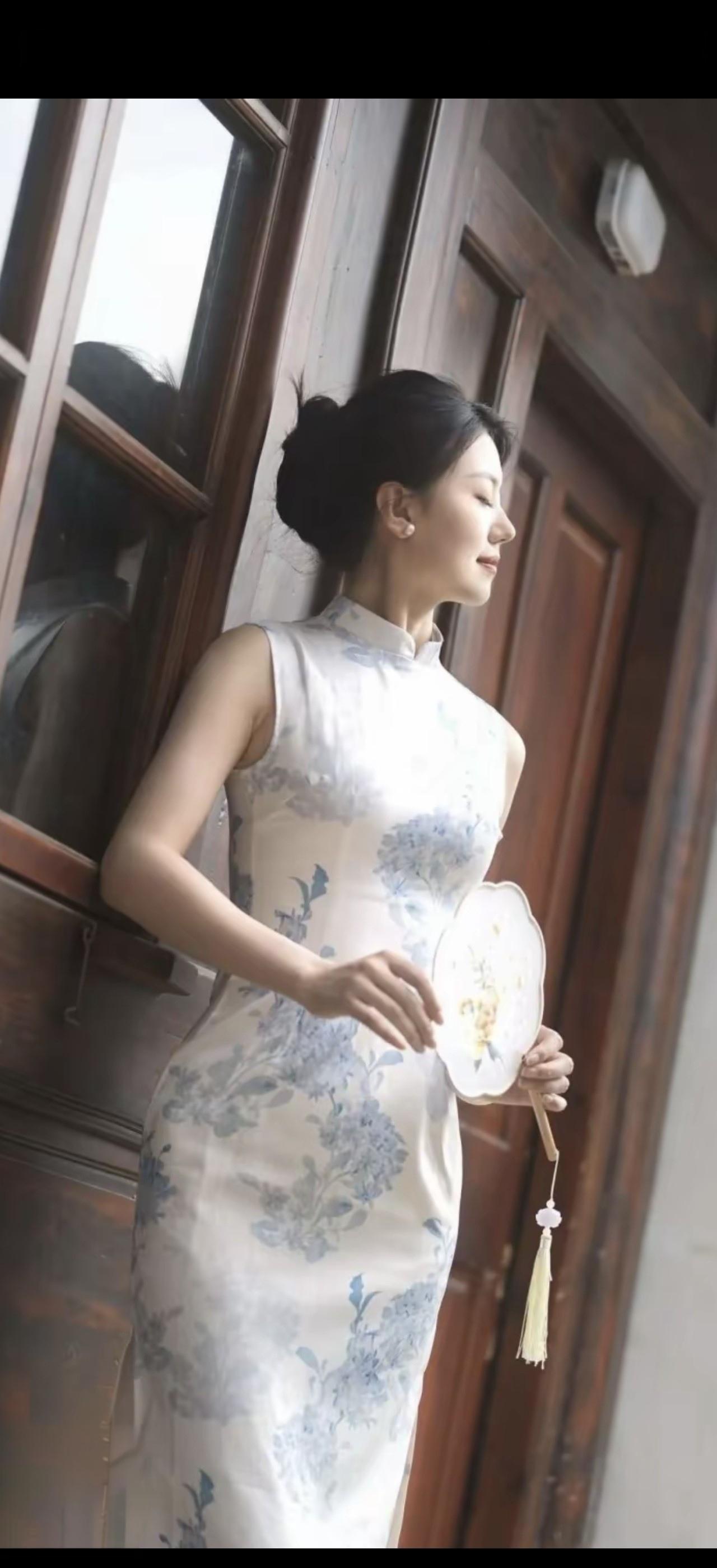 穿着旗袍的女士在窗边。