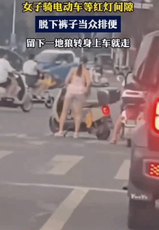 等红灯时路中间直接脱裤子小便！ 一名女子在路口等红灯期间，直接在路边就地方便，结