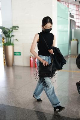黄多多现身北京机场
身穿黑色无袖上衣搭配牛仔裤
凉快又率性十足
黑色与蓝色的碰撞