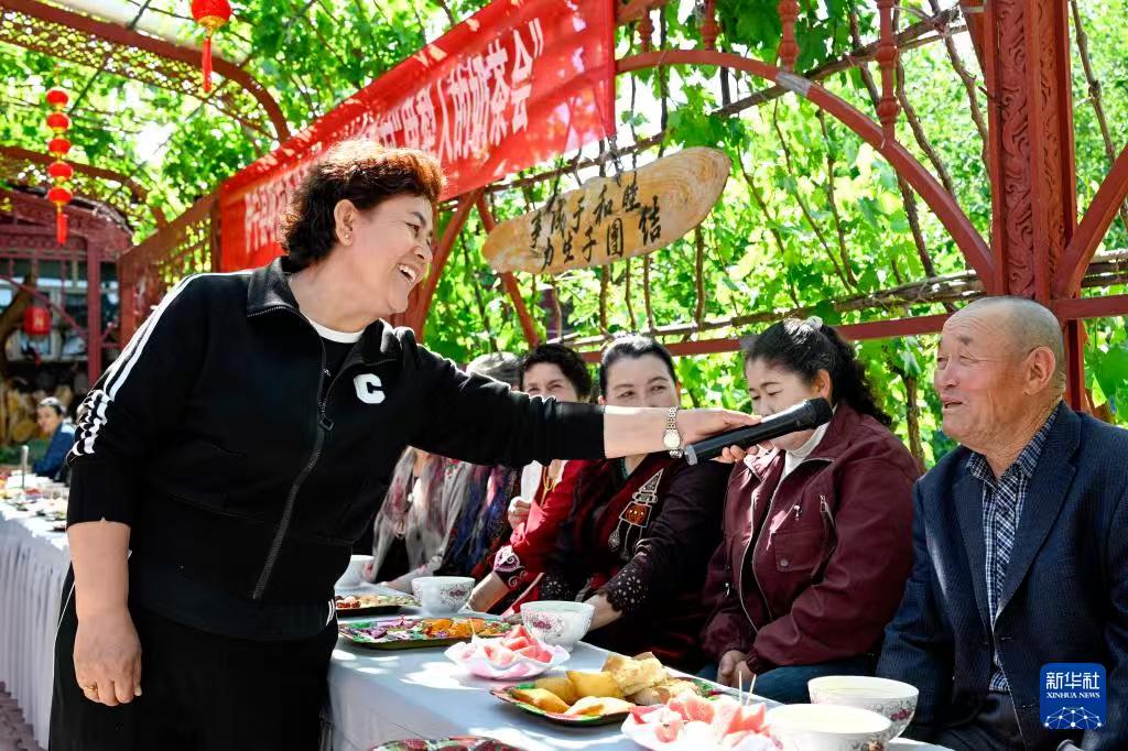 基层治理在新疆。

小院内，葡萄架下，几条长桌，几把凳子，乡村两级干部代表和村民