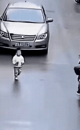 为了在车轮前救下这个在马路上乱走的孩子，两个路过的外卖小哥，采取了紧急措施。
