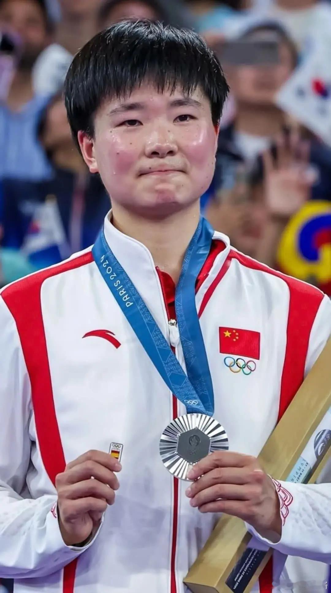 她手里拿的西班牙国旗。原因:她的对手西班牙选手因病没能进入下一轮，所以拿着一起摘