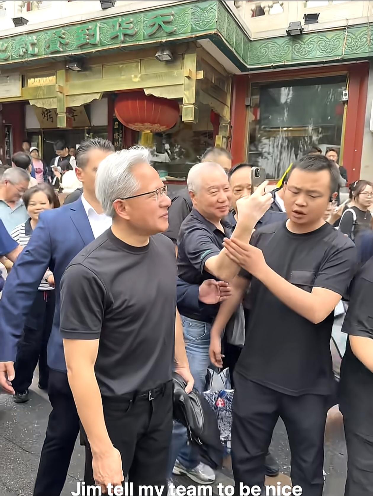 黄仁勋在北京街头与粉丝互动，保镖感到压力山大。在人群中，粉丝们争着和黄仁勋合影留