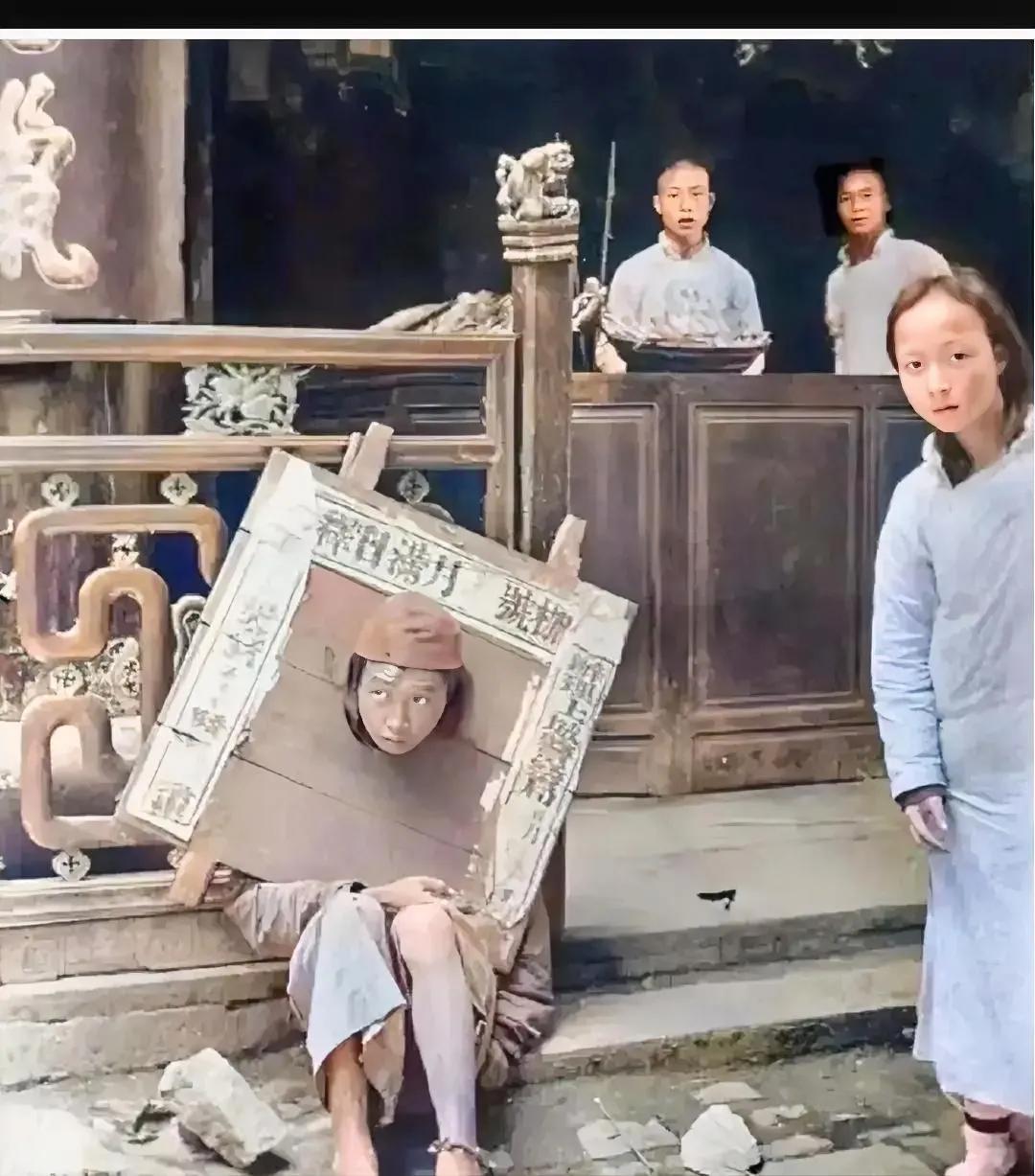 1908年，上海街头，一名戴着“木枷”的犯人，正坐在台阶上休息，看起来眼神非常空