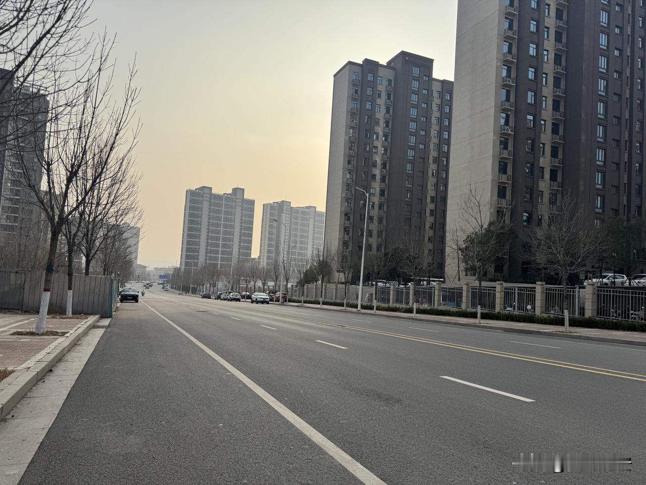 暮色像一层薄纱，轻轻罩在城市的上空。宽阔的柏油路在脚下延伸，白色的分道线笔直地指