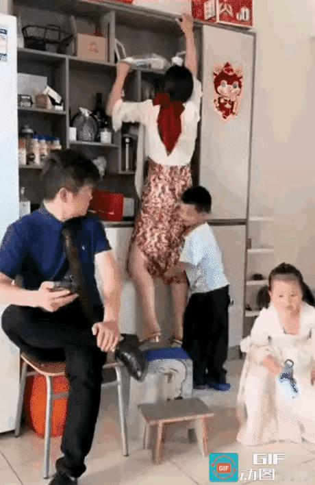 周末到了，一家四口正在家里面休息，丈夫则坐在椅子上玩手机，两个孩子则自顾自的玩耍