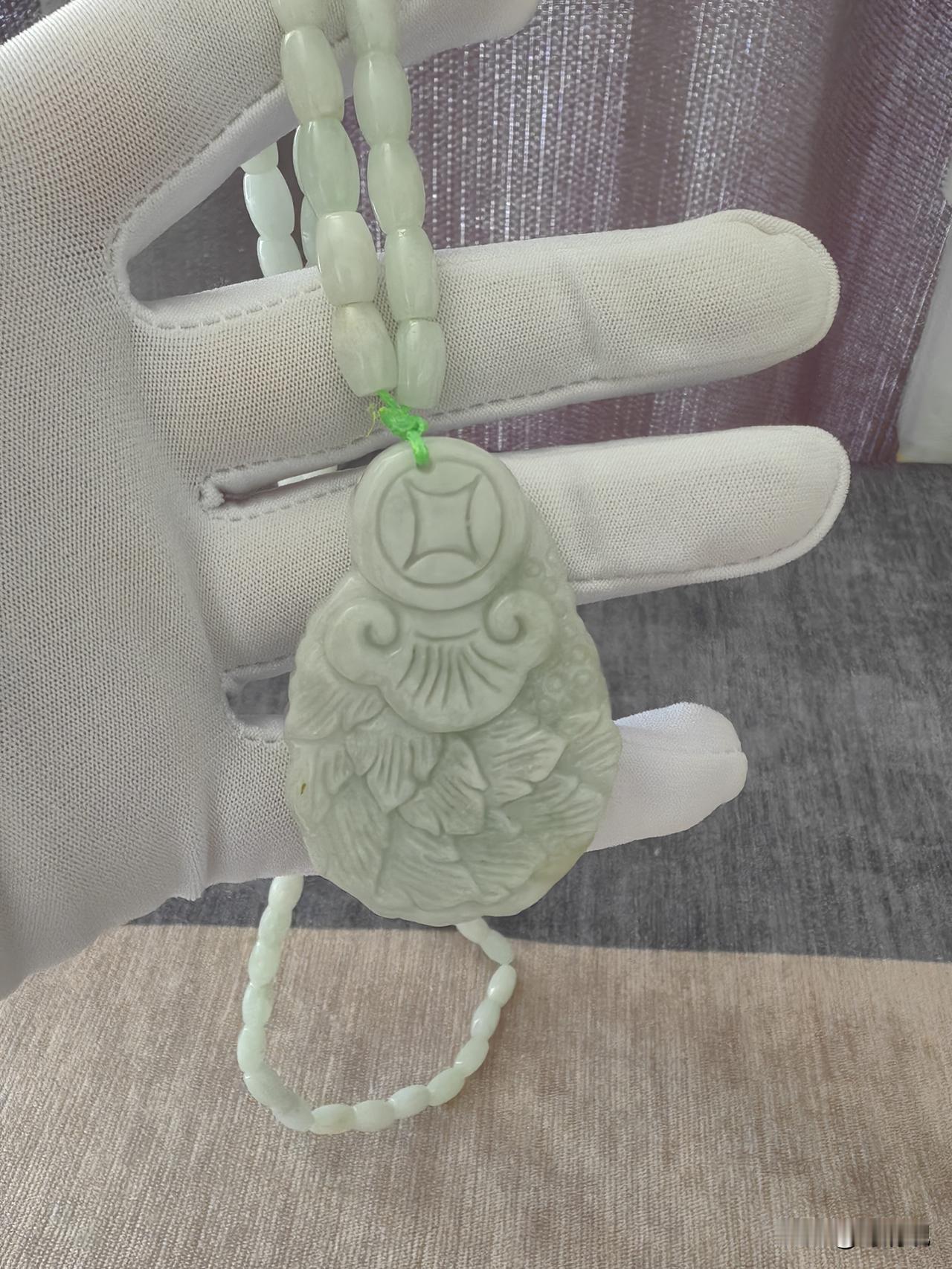 不是那种高冰天价货，就是很实在的淡青底色，看着温润舒服。吊坠上面雕刻铜钱、如意还
