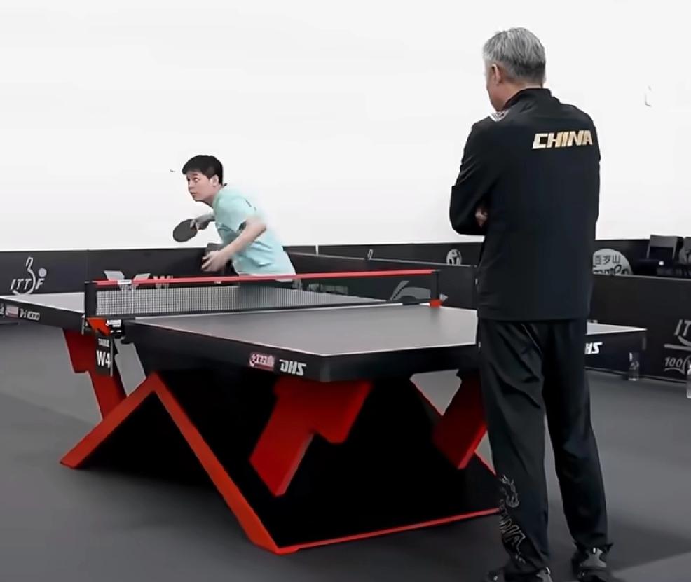 新加坡大满贯训练场，
你们来看看这是谁在教林诗栋发球？
没错，是国乒总教练秦志戬