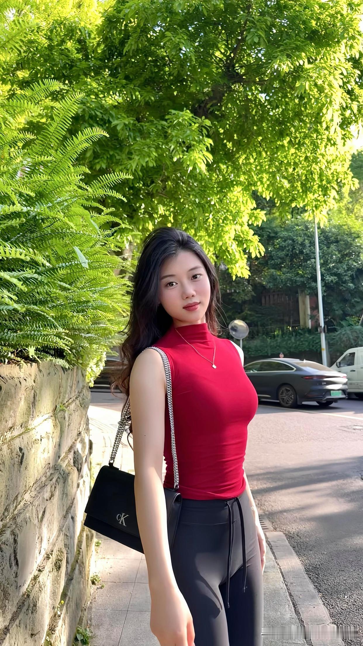 阳光下的时尚街拍，红衣少女与粉墙绿树相映成趣。