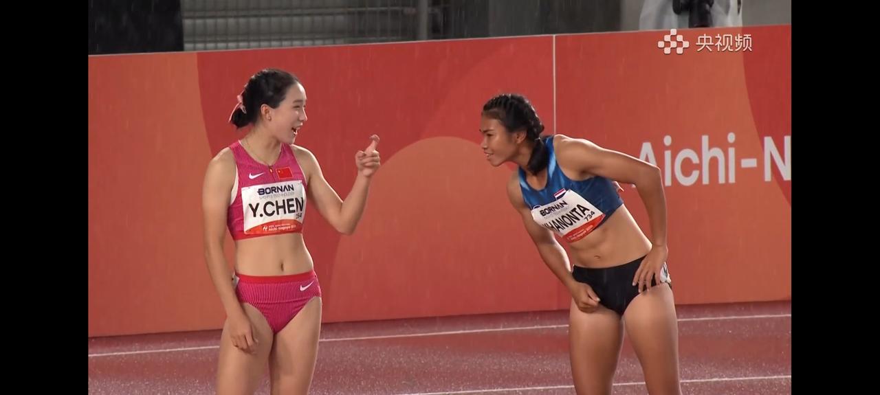 当女子4×100米接力决赛第四棒的陈妤颉和旁边的泰国选手想交流一下。
说了半天普
