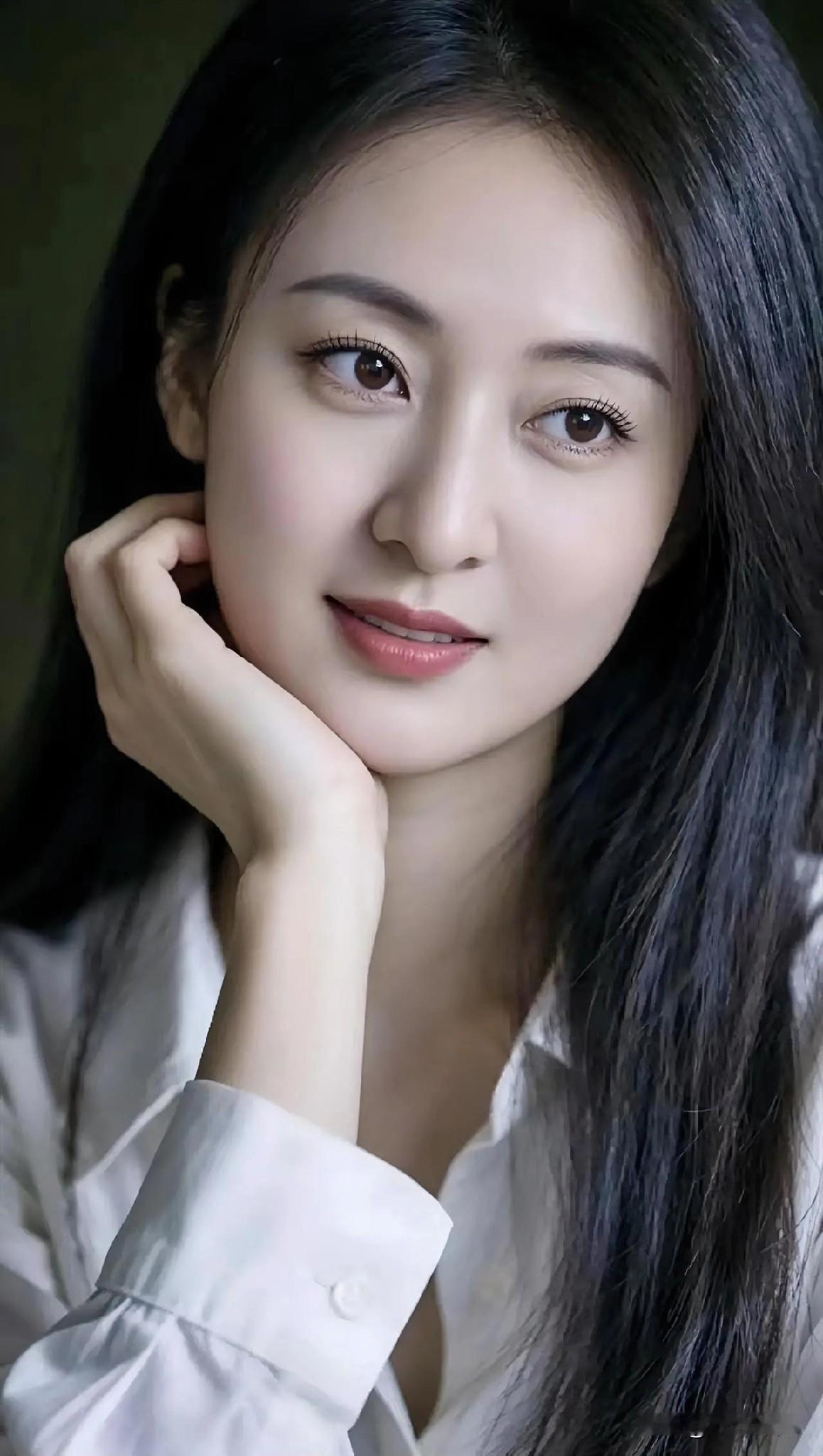 白衬衫洇着月光，她倚着静谧的夜。

长发如墨瀑，垂落温柔的浪。

指尖轻托腮边，