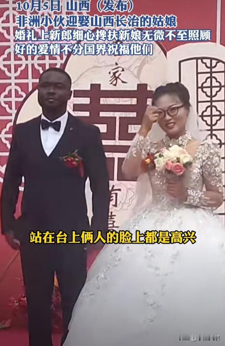 山西姑娘远嫁非洲黑人，
举行婚礼时黑人拉着新娘，新娘也是很高兴的样子，祝福他们，