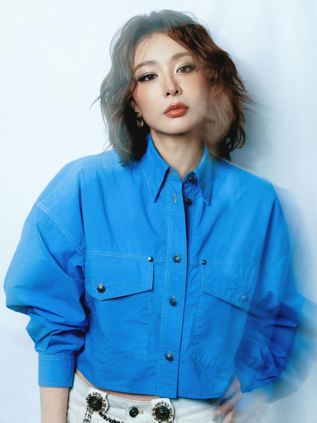 一袭明亮克莱因蓝，利落剪裁勾勒飒爽气场。慵懒卷发裹挟随性质感，精致钉珠细节点亮穿