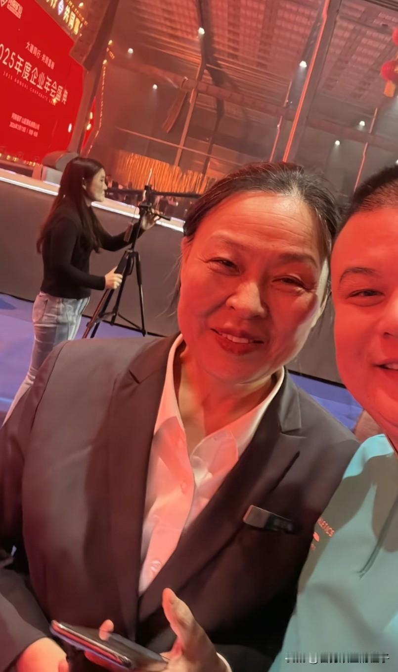 矿山年会上最累的人郭玉梅，终于忙完了，趁着休息的功夫，有网友上前去和她拍照，看她