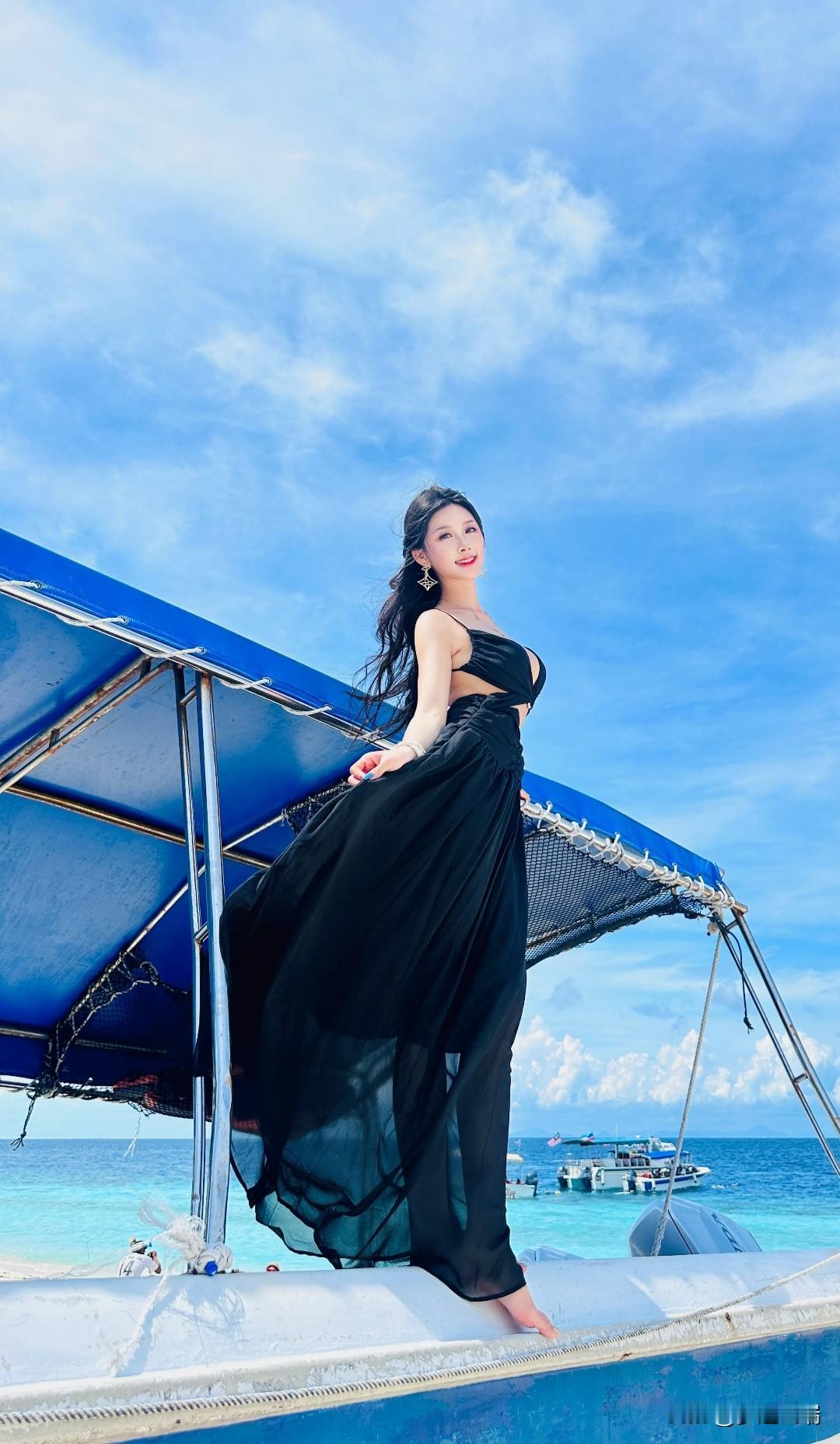 海边漫步，黑裙飘飘，享受阳光与海风。