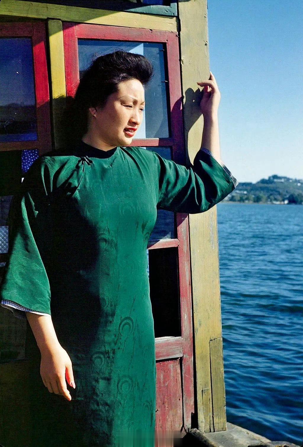 1945年，杭州。民国时期，船上一位漂亮清爽的少妇。她穿着绿色旗袍，有着优雅出众