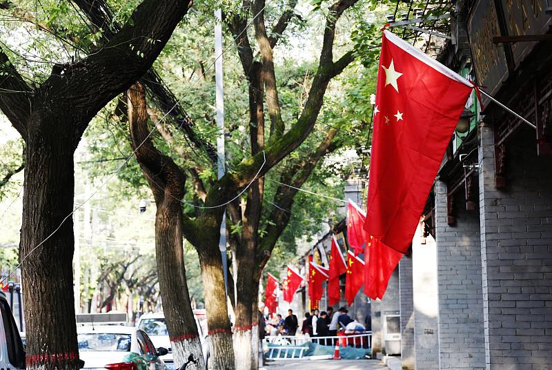 今早出门路过单位门口，看见整条街的商铺都挂起了五星红旗，风一吹红通通的一片，连路