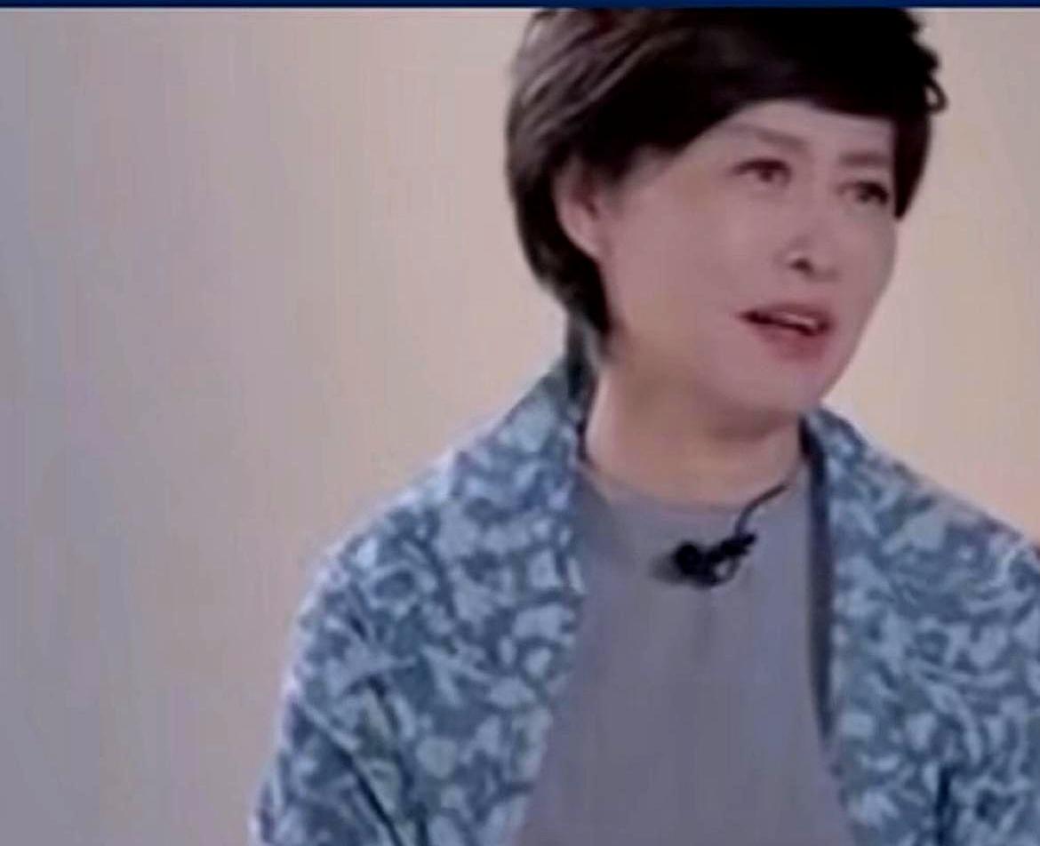 她在街头看见一条层层纱裙时，和身边的女儿对视一下，笑里有酸。
说的人是敬一丹。