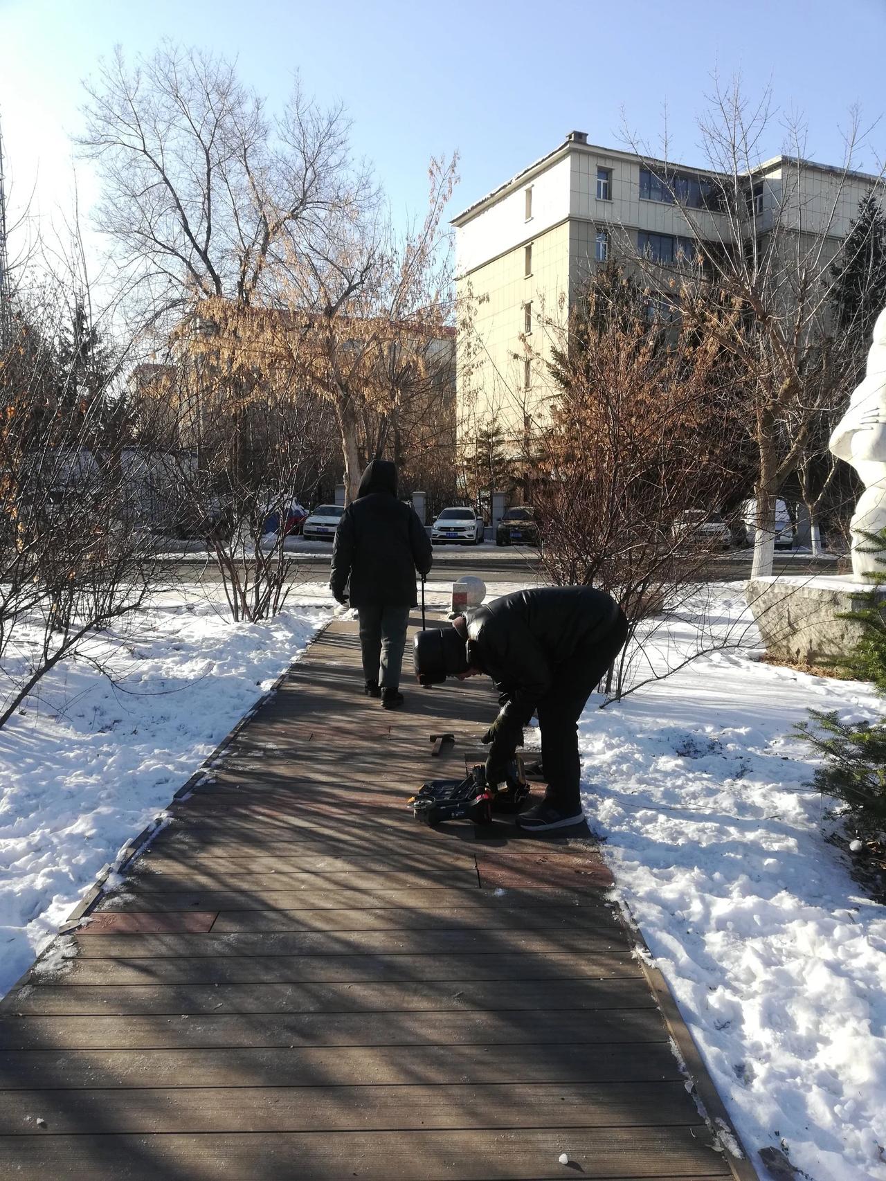 在长春市绿园区锦江公园，工人师傅在修复更换公园林荫小径上的路板。向他们的辛勤付出