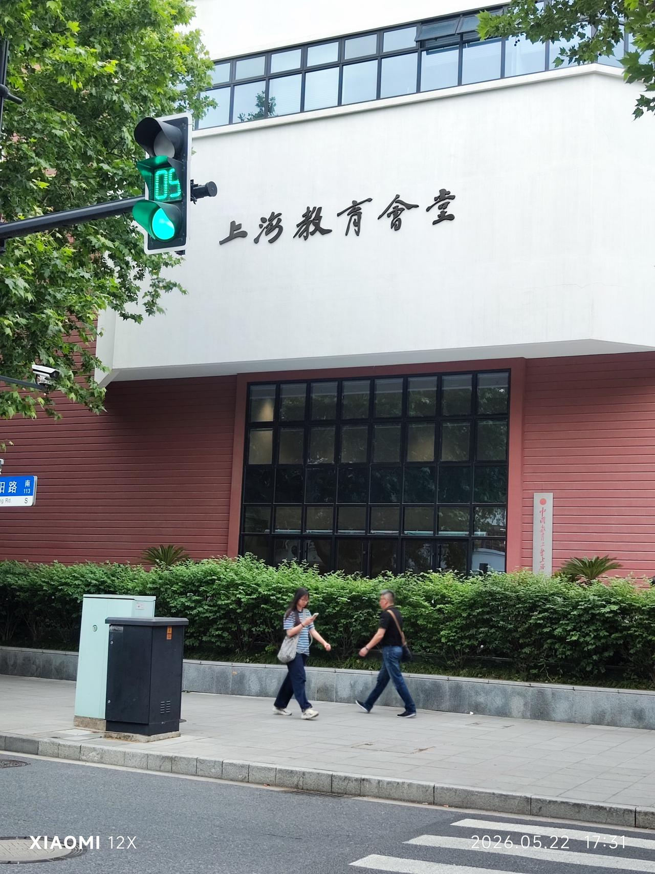 上海教育会堂
 
红砖与白墙，衬着路口的灯，
“上海教育会堂”的字，温温地亮着。