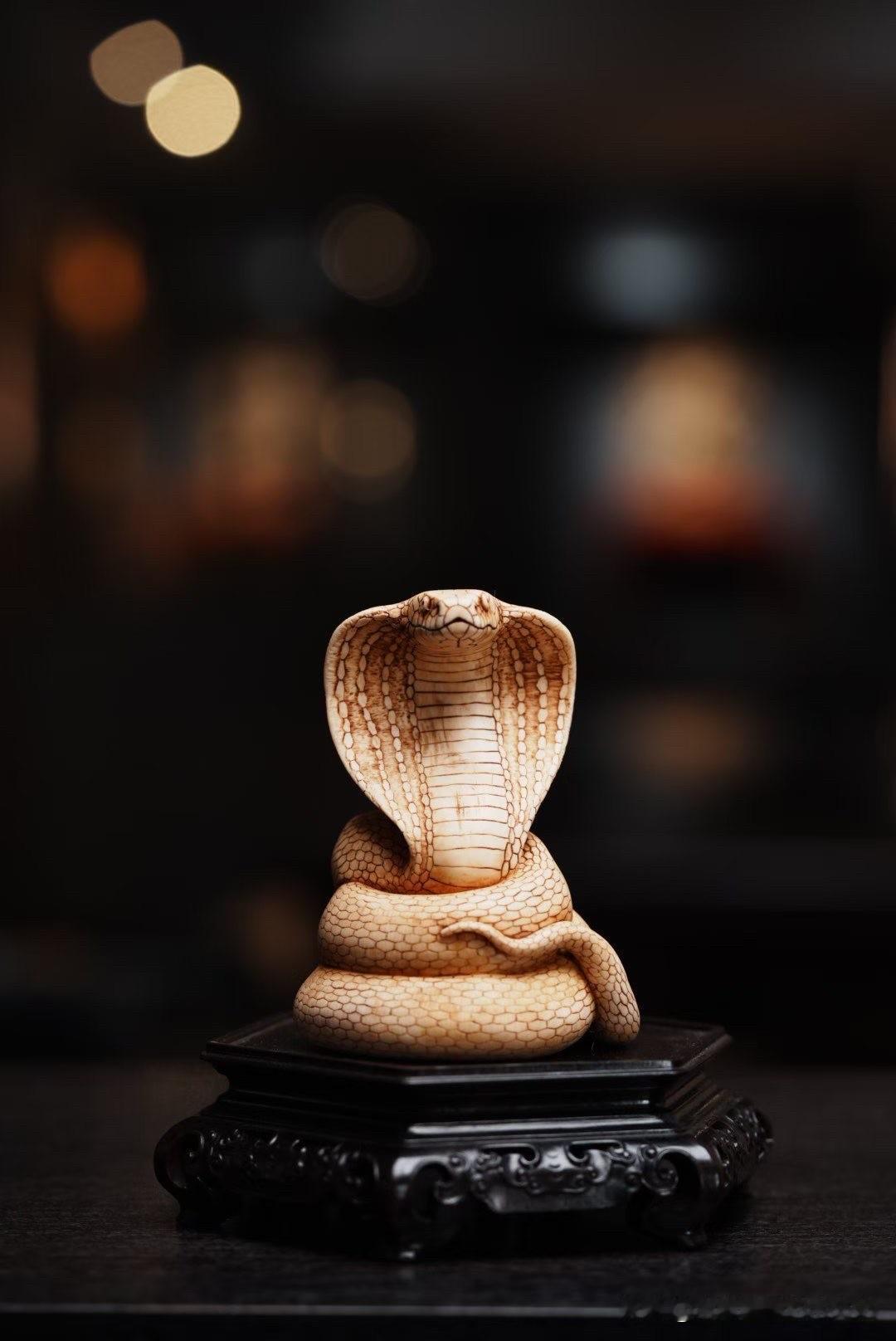 蛇首昂起，自带一股令人屏息的压迫感。

这件猛犸象牙《虺尊》，以蛇王为题，着力刻